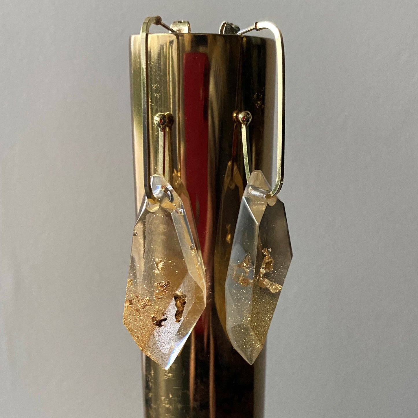 Oorbellen goudkleurige edelstaal met diamantvormige hanger met 18K goudvlokken